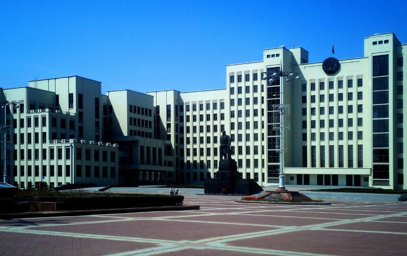 Концепция защиты туристов: щит защищает документы и деньги на фоне официального здания в Беларуси