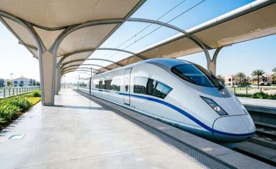 Современный скоростной поезд Etihad Rail на станции в Дубае с пассажирами на платформе, ОАЭ 2026 год